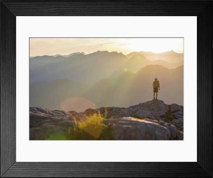 Framed Print : Backpacker stands on rock outcrop, looking out at view Framed Print : Backpacker stands on rock outcrop, looking out at view