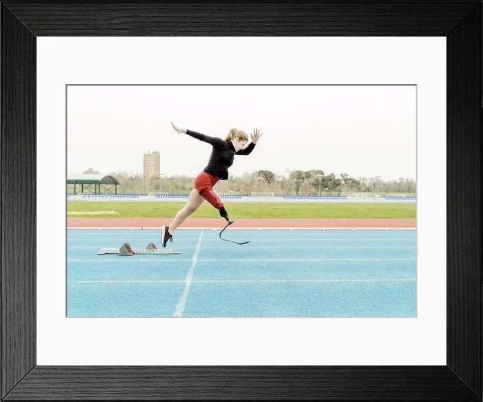 Framed Print : Sportswoman with prosthetic leg running near the starting blocks Framed Print : Sportswoman with prosthetic leg running near the starting blocks