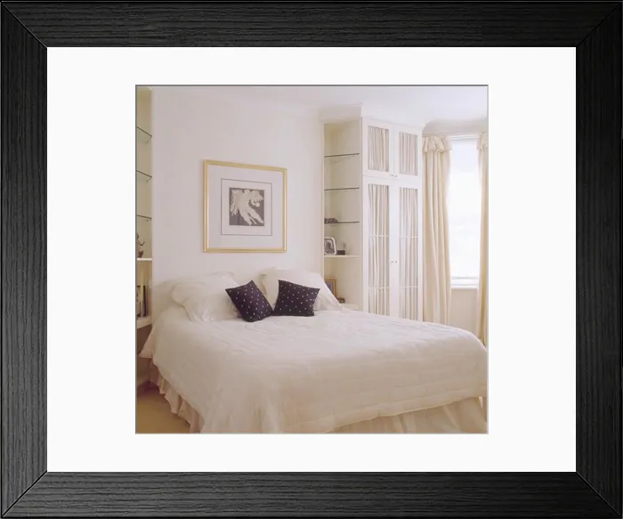 Framed Print : Black and white cushions on white quilt on bed in modern white bedroom with built in wardrobe and shelves Framed Print : Black and white cushions on white quilt on bed in modern white bedroom with built in wardrobe and shelves