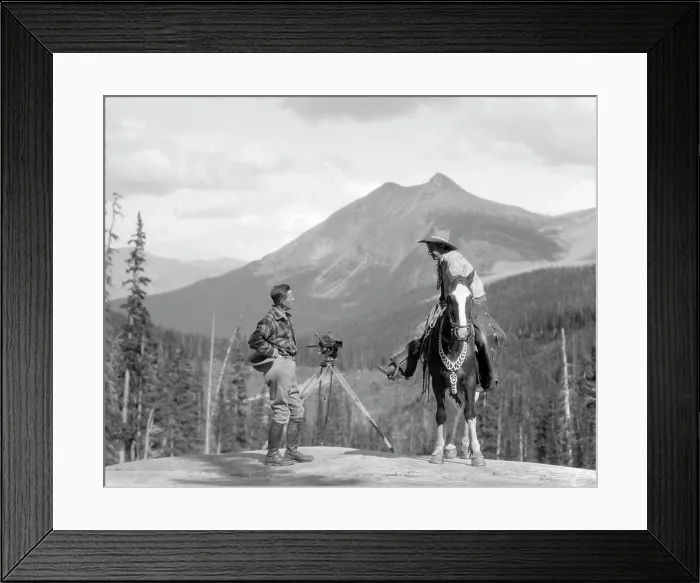 Framed Print : 1930S Cameraman In Boots Jodhpurs & Wool Hunting Shirt Standing Next To Movie Camera On Tripod Talking To Mounted Cowboy Framed Print : 1930S Cameraman In Boots Jodhpurs & Wool Hunting Shirt Standing Next To Movie Camera On Tripod Talking To Mounted Cowboy