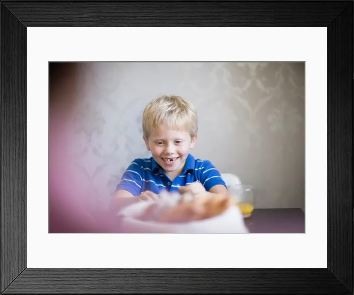 Framed Print : Boy smiling at dinner table Framed Print : Boy smiling at dinner table