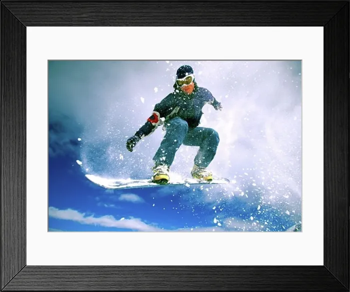 Framed Print : Low angle view of a young man snowboarding Framed Print : Low angle view of a young man snowboarding