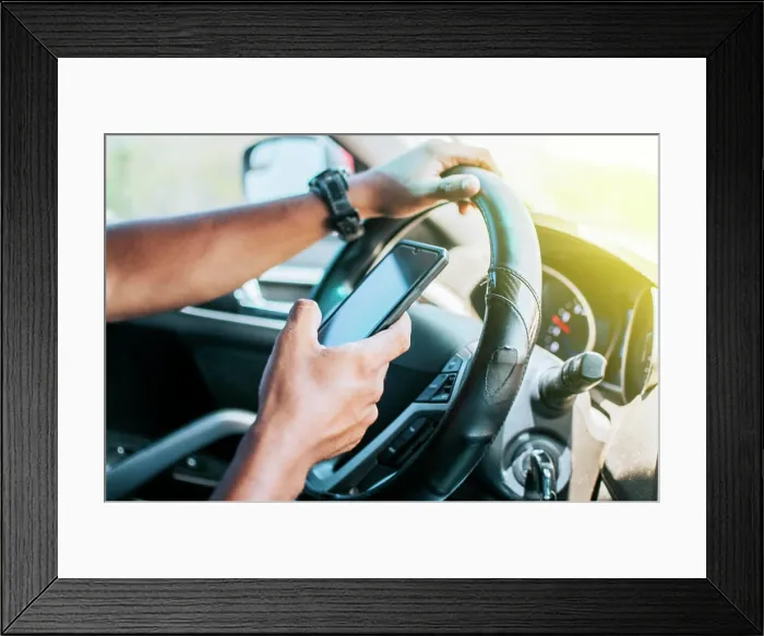 Framed Print : Person in his car using cell phone