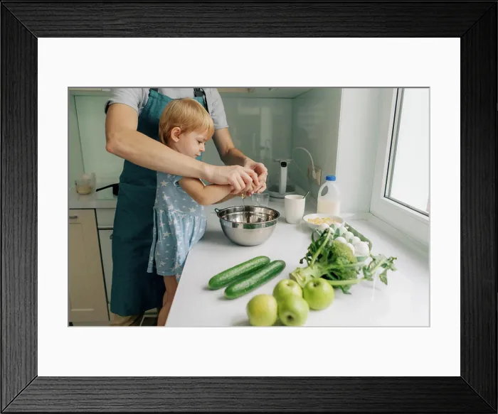 Framed Print : Mom teaches her little daughter how to cook dinner Framed Print : Mom teaches her little daughter how to cook dinner