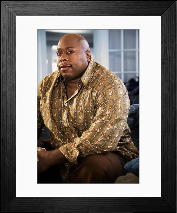 Framed Print : Serious Black man sitting on sofa Framed Print : Serious Black man sitting on sofa