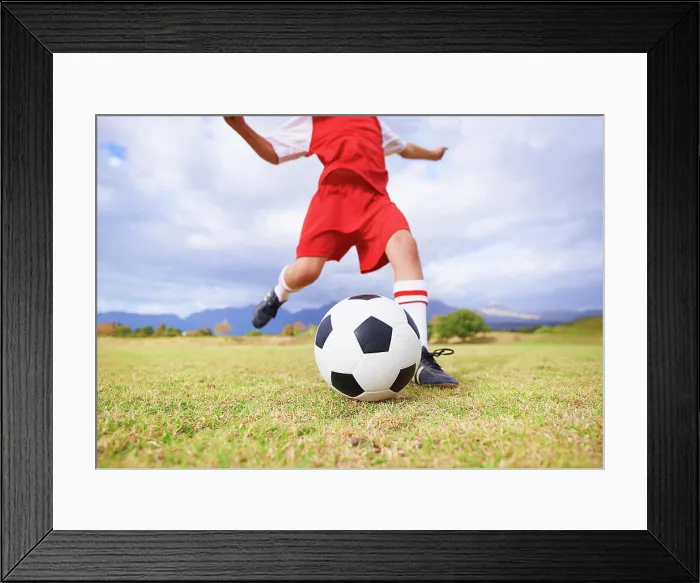 Framed Print : Child, kicking and soccer ball on green grass for sports