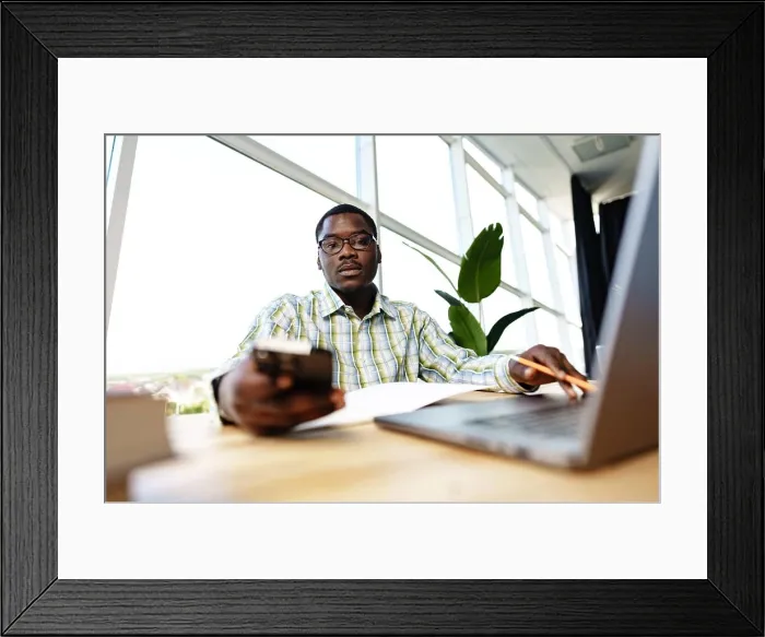 Framed Print : Serious concentrated african man studying or working with laptop indoors Framed Print : Serious concentrated african man studying or working with laptop indoors