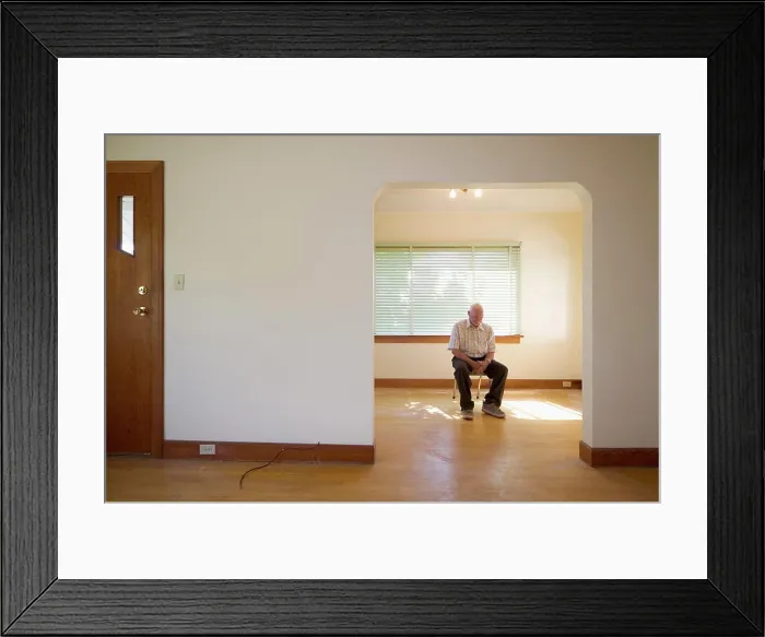 Framed Print : senior citizen 70-80 years old sitting on chair in vacant house, Canada Framed Print : senior citizen 70-80 years old sitting on chair in vacant house, Canada
