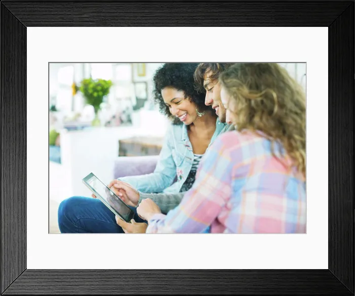 Framed Print : Friends using tablet computer on sofa Framed Print : Friends using tablet computer on sofa