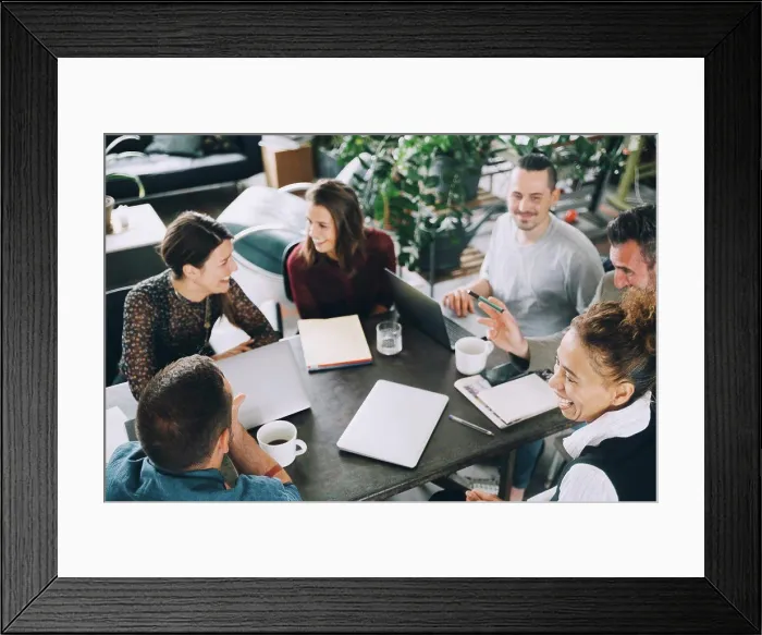 Framed Print : High angle view of happy business people sitting at table in creative office