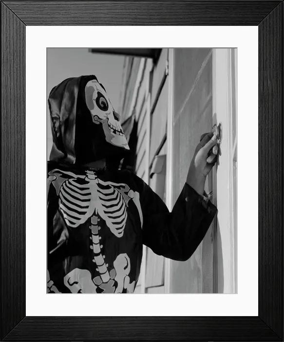 Framed Print : Person ringing doorbell wearing as skeleton