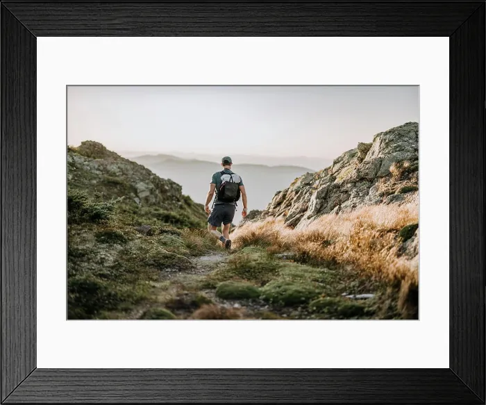 Framed Print : hiker with white backpack descends through rocky trail Framed Print : hiker with white backpack descends through rocky trail
