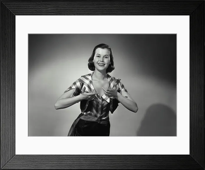 Framed Print : Vintage Photograph. Woman wears silky striped shirt while having her hands raised she smiles in studio portrait Framed Print : Vintage Photograph. Woman wears silky striped shirt while having her hands raised she smiles in studio portrait