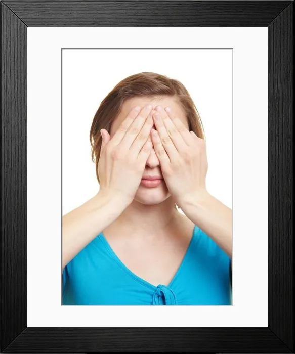 Framed Print : Young woman covering her eyes with both hands