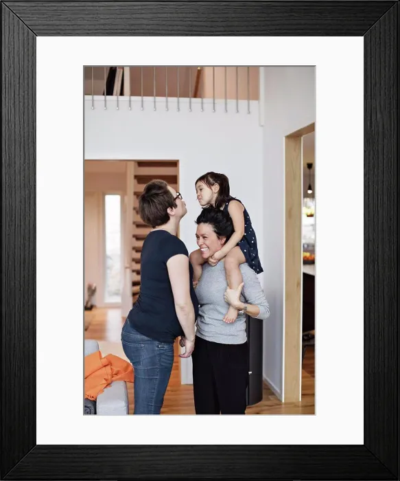 Framed Print : Smiling family enjoying while standing in living room at home Framed Print : Smiling family enjoying while standing in living room at home