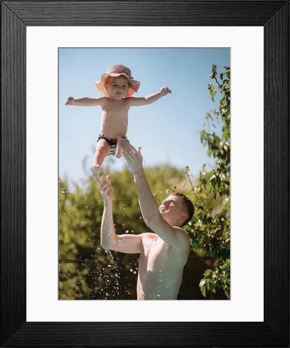 Framed Print : Little girl in a hat swims in the pool with dad Framed Print : Little girl in a hat swims in the pool with dad