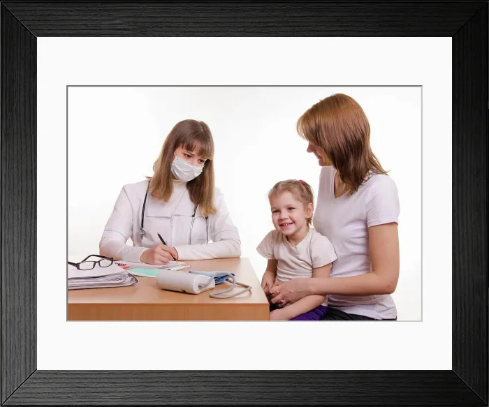 Framed Print : Young mother with her child sitting in his office at the pediatrician Woman with a small child on reception