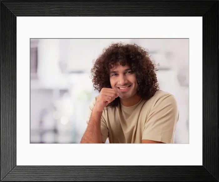 Framed Print : A HAPPY YOUNG MAN WITH CURLY HAIR SMILING CHEERFULLY AT CAMERA Framed Print : A HAPPY YOUNG MAN WITH CURLY HAIR SMILING CHEERFULLY AT CAMERA