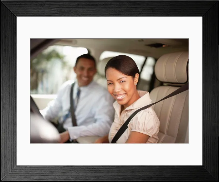 Framed Print : Man and woman sitting in car smiling at the camera Framed Print : Man and woman sitting in car smiling at the camera