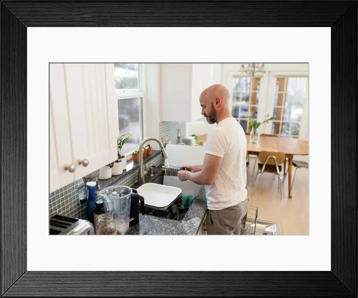 Framed Print : Man rinsing dishes in kitchen Framed Print : Man rinsing dishes in kitchen