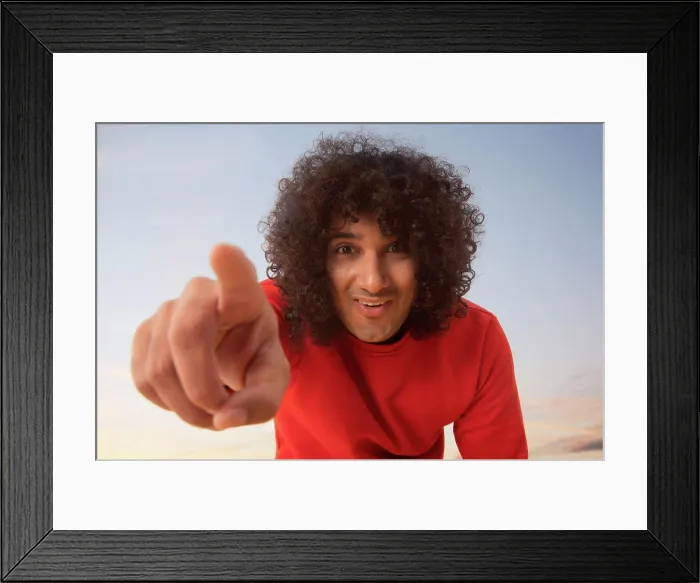 Framed Print : A YOUNG MAN WITH CURLY HAIR HAPPILY POINTING FINGER TOWARDS CAMERA Framed Print : A YOUNG MAN WITH CURLY HAIR HAPPILY POINTING FINGER TOWARDS CAMERA