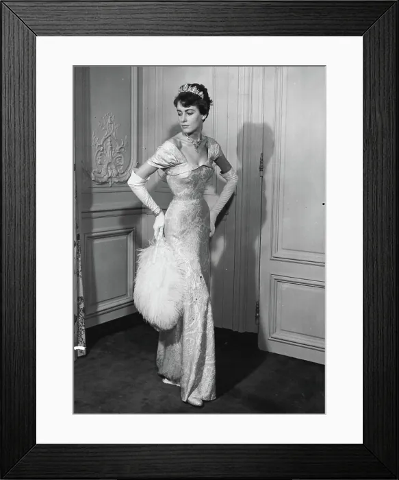 Framed Print : Moulded over the figure, Mattli's white and silver lame court dress falls into a graceful train at the back