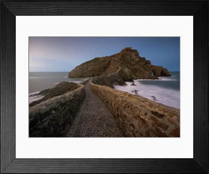 Framed Print : Waves beating against medieval stone bridge leading to small rocky island with San Juan de Gaztelugatxe hermitage