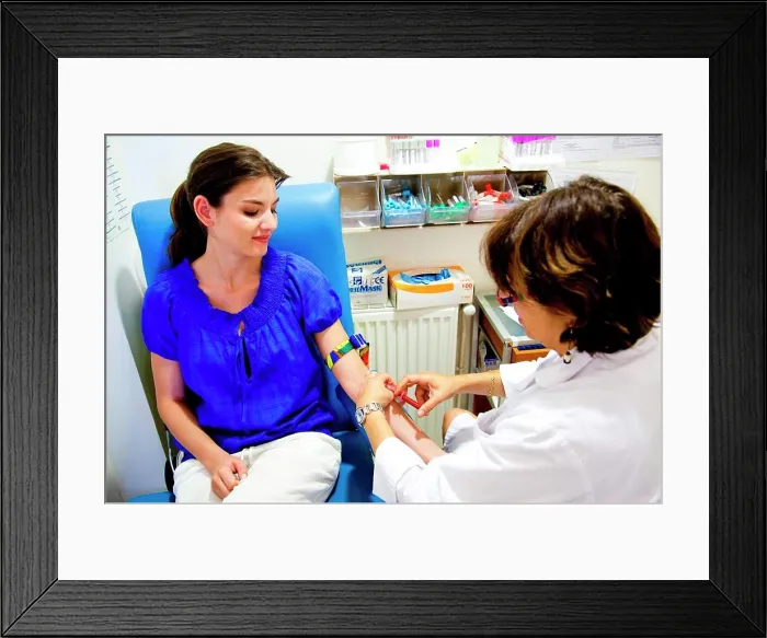 Framed Print : Young woman having a blood sample Framed Print : Young woman having a blood sample