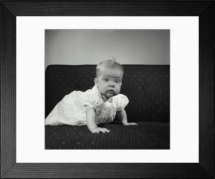 Framed Print : Baby girl crawling on a couch Framed Print : Baby girl crawling on a couch