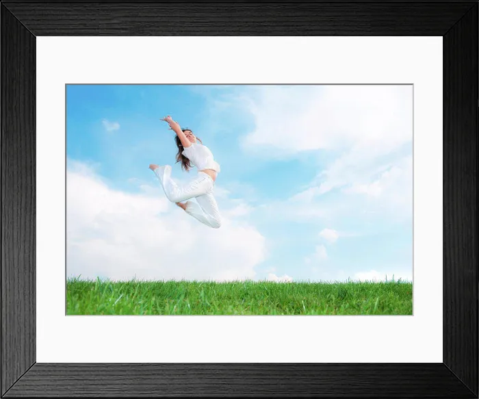 Framed Print : Young woman jumping on meadow Framed Print : Young woman jumping on meadow