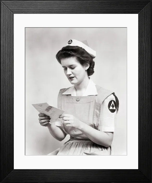 Framed Print : 1940s WOMAN SERVING VOLUNTEER RED CROSS NURSE WEARING UNIFORM SMOCK DRESS AND CAP READING LETTER DURING WORLD WAR 2 Framed Print : 1940s WOMAN SERVING VOLUNTEER RED CROSS NURSE WEARING UNIFORM SMOCK DRESS AND CAP READING LETTER DURING WORLD WAR 2
