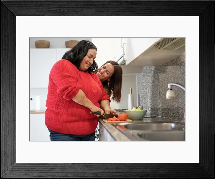 Framed Print : Two diverse friends preparing lunch in the kitchen with her friend Framed Print : Two diverse friends preparing lunch in the kitchen with her friend