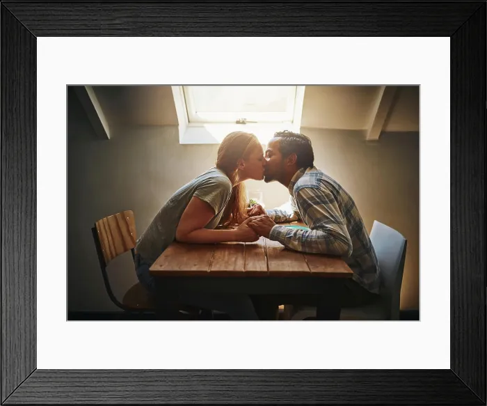 Framed Print : Kiss, couple love and holding hands at cafe on table Framed Print : Kiss, couple love and holding hands at cafe on table