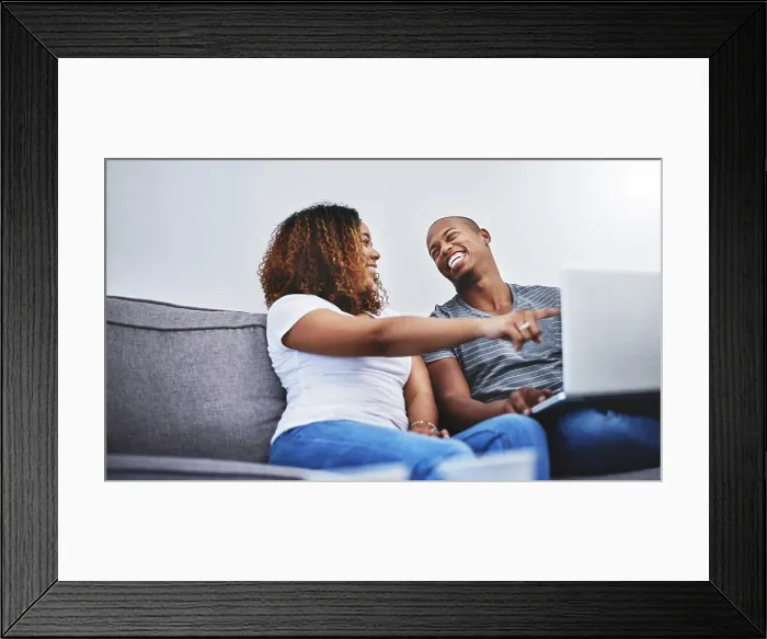 Framed Print : Pointing, laptop and couple on sofa for online shopping Framed Print : Pointing, laptop and couple on sofa for online shopping