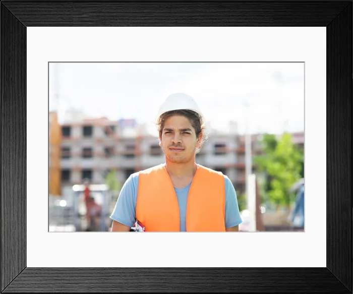 Framed Print : young construction engineer with helmet working outside Framed Print : young construction engineer with helmet working outside
