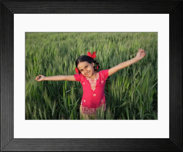 Framed Print : Portrait of a carefree little girl standing with arms out in a wheat field Framed Print : Portrait of a carefree little girl standing with arms out in a wheat field