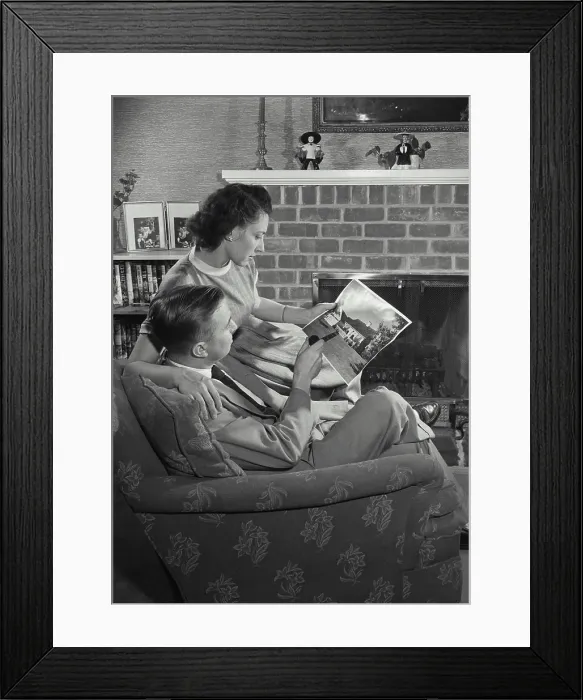 Framed Print : Vintage Photograph. Man and Wife sitting in chair and looking at picture. Frame 4 Framed Print : Vintage Photograph. Man and Wife sitting in chair and looking at picture. Frame 4