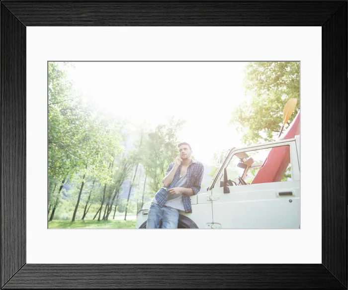 Framed Print : Man leaning on his vehicle during a sunny outdoor adventure