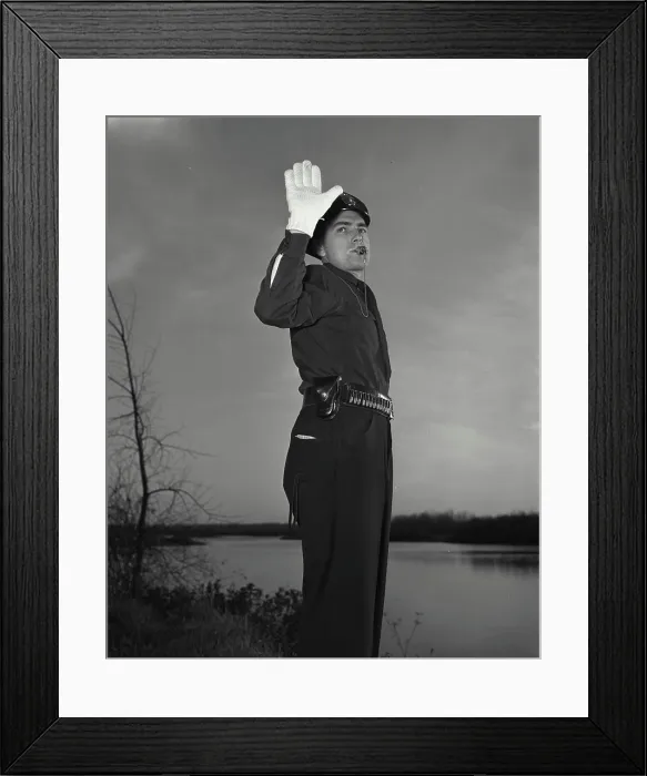Framed Print : Vintage photograph. Policeman blowing whistle while holding up hand Framed Print : Vintage photograph. Policeman blowing whistle while holding up hand