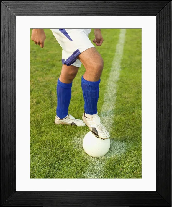 Framed Print : A soccer player with his foot on a soccer ball Framed Print : A soccer player with his foot on a soccer ball