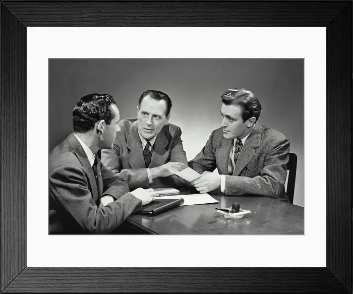 Framed Print : Vintage photograph. Group of businessmen sitting at desk having meeting
