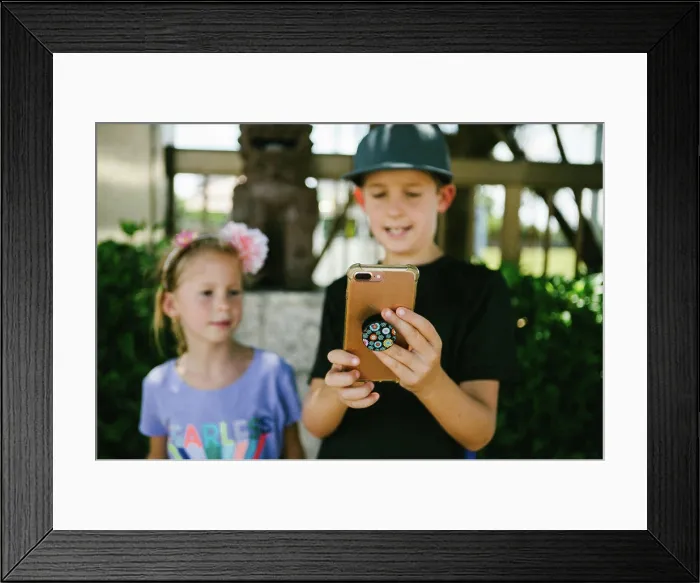 Framed Print : Brother and sister use smart phone together Framed Print : Brother and sister use smart phone together
