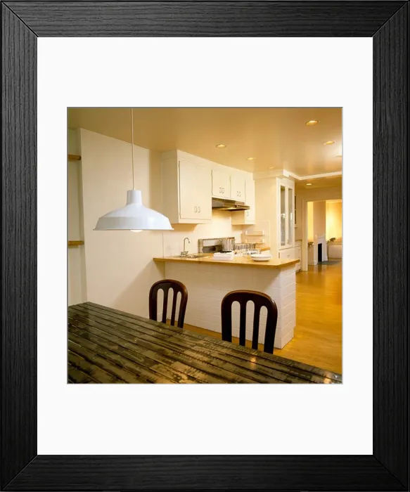 Framed Print : White pendant light above ridged metal table in modern white kitchen Framed Print : White pendant light above ridged metal table in modern white kitchen