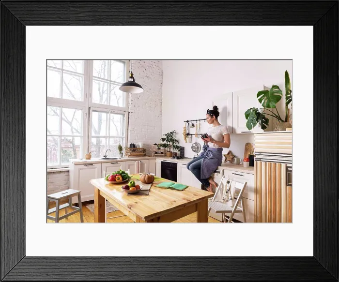 Framed Print : Young and beautiful housewife woman cooking in a white kitchen