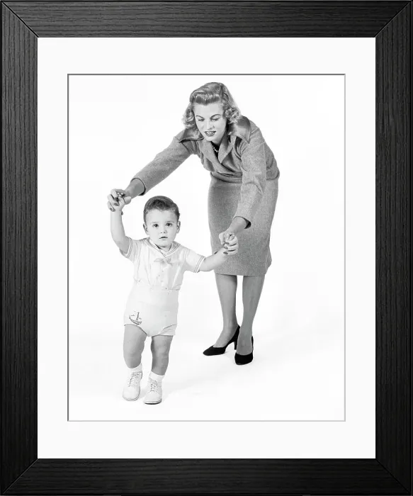 Framed Print : 1950s 1960s CONCERNED PROUD MOTHER WATCHING HELPING BABY BOY TAKING FIRST STEPS WALKING LOOKING AT CAMERA Framed Print : 1950s 1960s CONCERNED PROUD MOTHER WATCHING HELPING BABY BOY TAKING FIRST STEPS WALKING LOOKING AT CAMERA