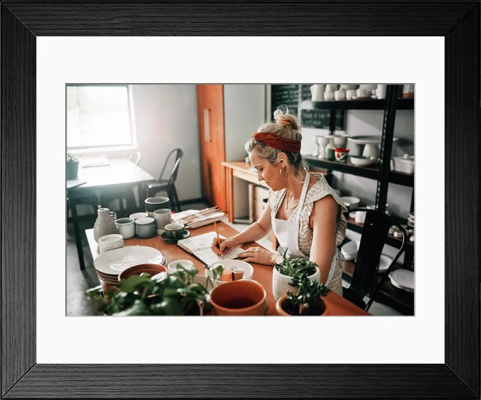 Framed Print : Writing, woman potter and book in workshop for planning Framed Print : Writing, woman potter and book in workshop for planning