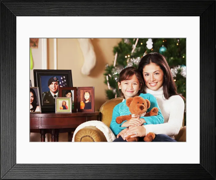 Framed Print : Mother holding daughter on lap at Christmas