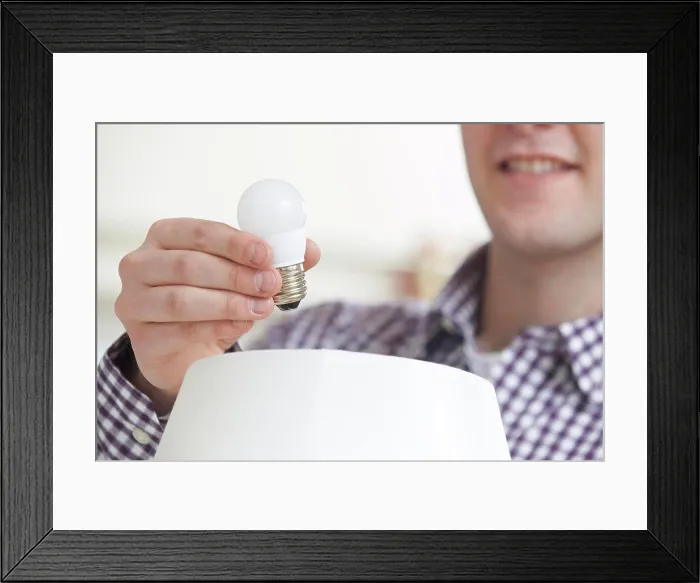 Framed Print : Man Putting Low Energy LED Lightbulb Into Lamp At Home Framed Print : Man Putting Low Energy LED Lightbulb Into Lamp At Home