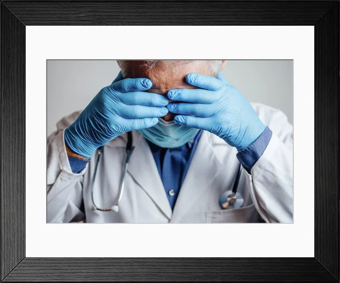 Framed Print : Doctor desperate for rest holding his hands on his head Framed Print : Doctor desperate for rest holding his hands on his head