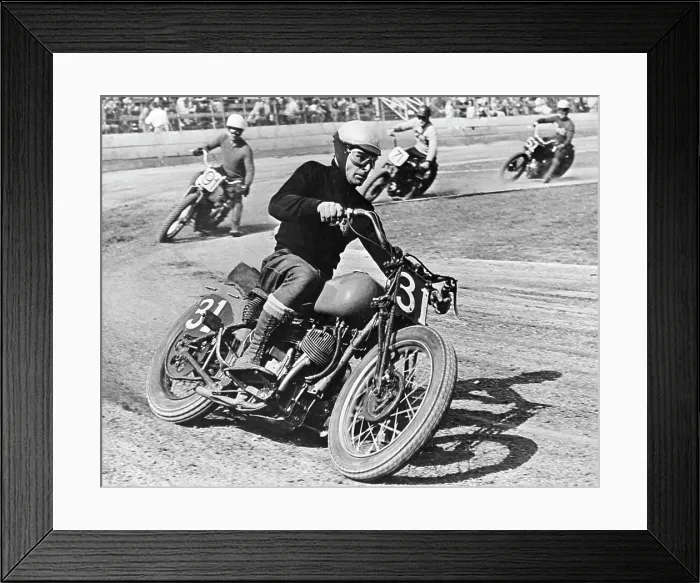 Framed Print : A grim-faced motorcycle racer skids through a turn as he leads the field on a 'figure 8' race track Framed Print : A grim-faced motorcycle racer skids through a turn as he leads the field on a 'figure 8' race track